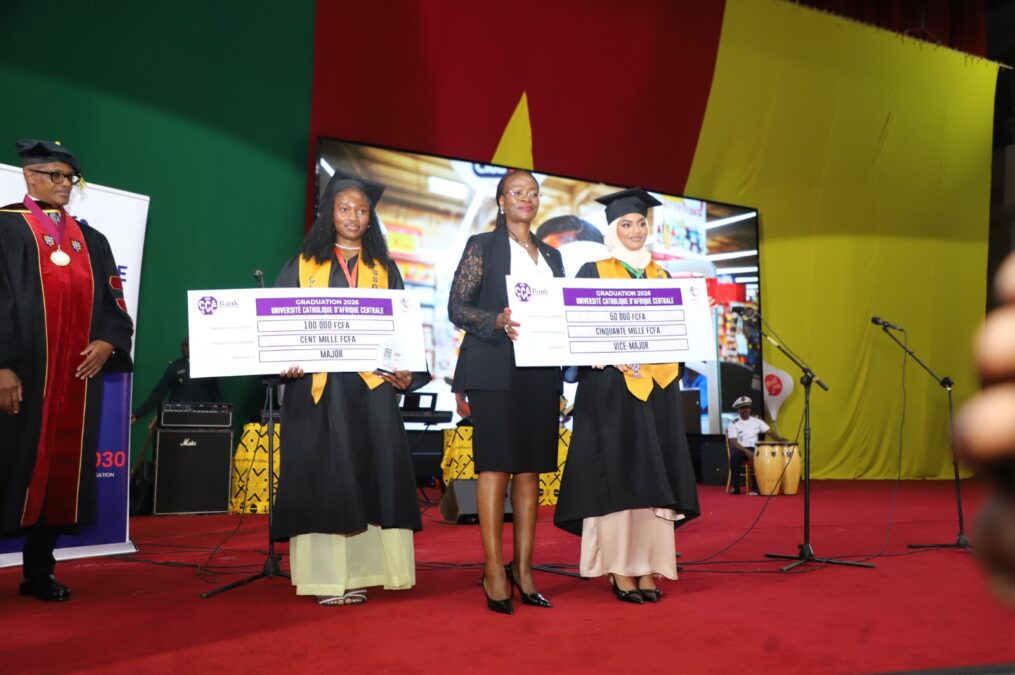 Cette photo immortabilise le moment où Mme Alvine Désirée Mefotie Fondop épouse Tiwoda, Directrice Générale de CCA-BANK, récompense les étudiants exceptionnels de la FSSG-UCAC. Elle remet des chèques géants aux majors de promotion, soulignant l'engagement de la banque à soutenir l'éducation et l'excellence au Cameroun.